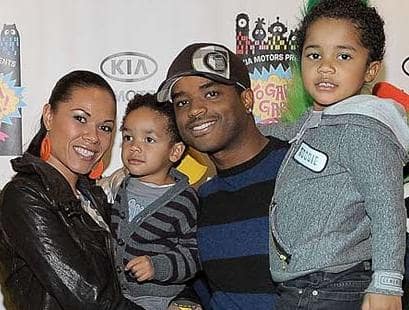 Tomasina Parrott in a black jacket posing with her children and husband.